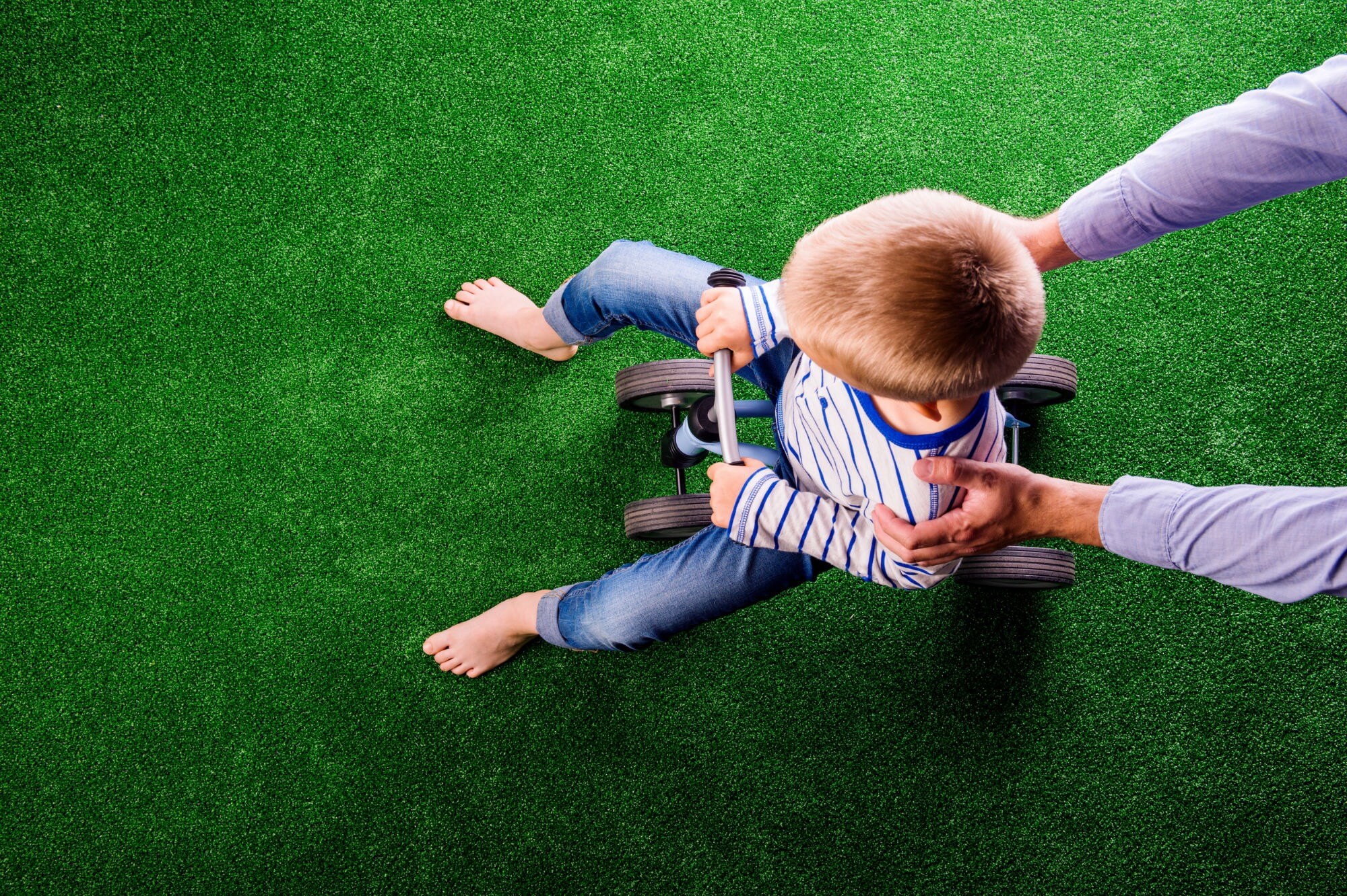 a kid playing on artificial grass