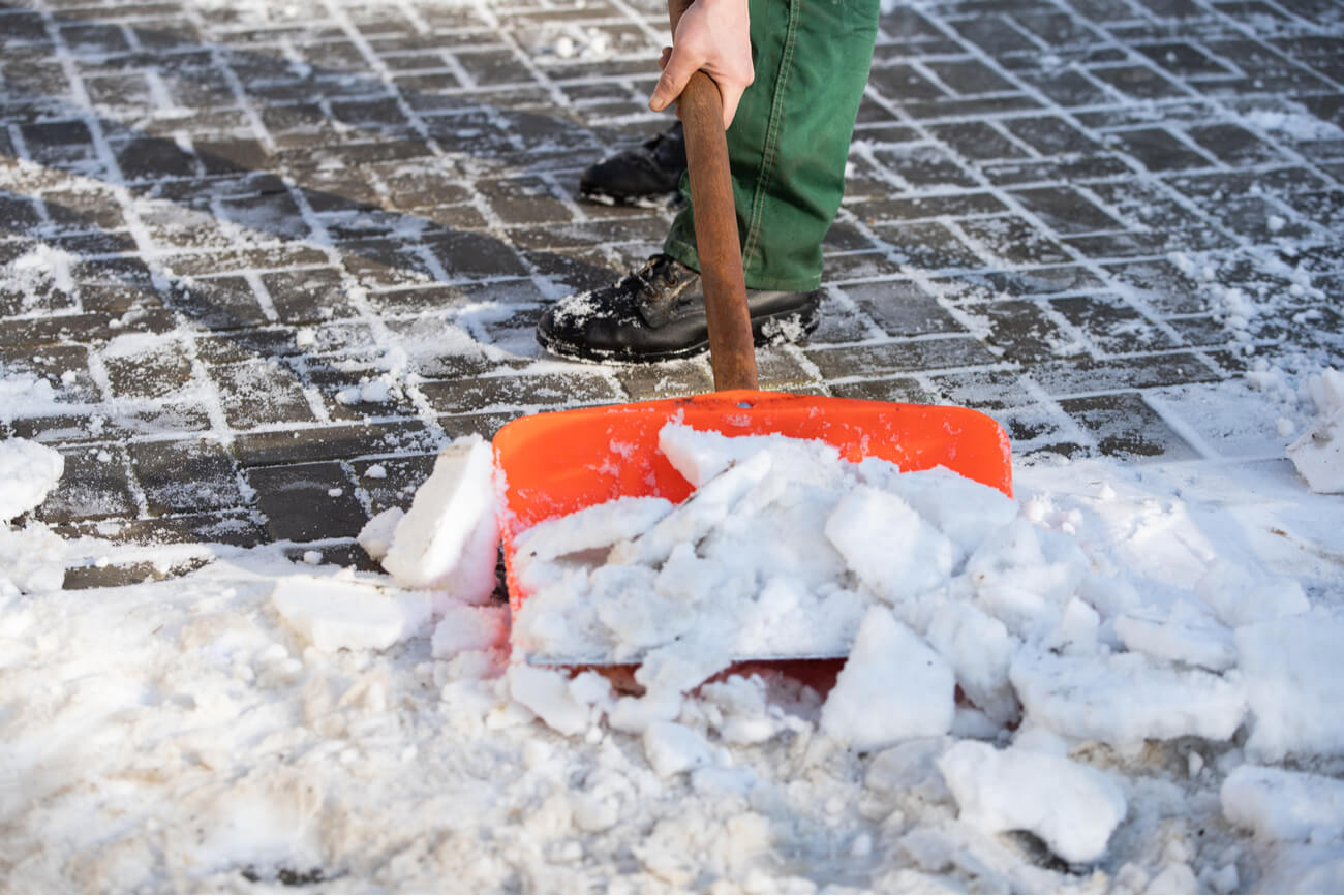 a person removing snow from a paved area