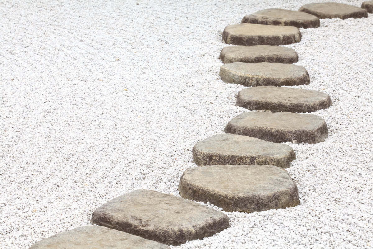 a Japanese garden design featuring a stone path and a gravel ground cover