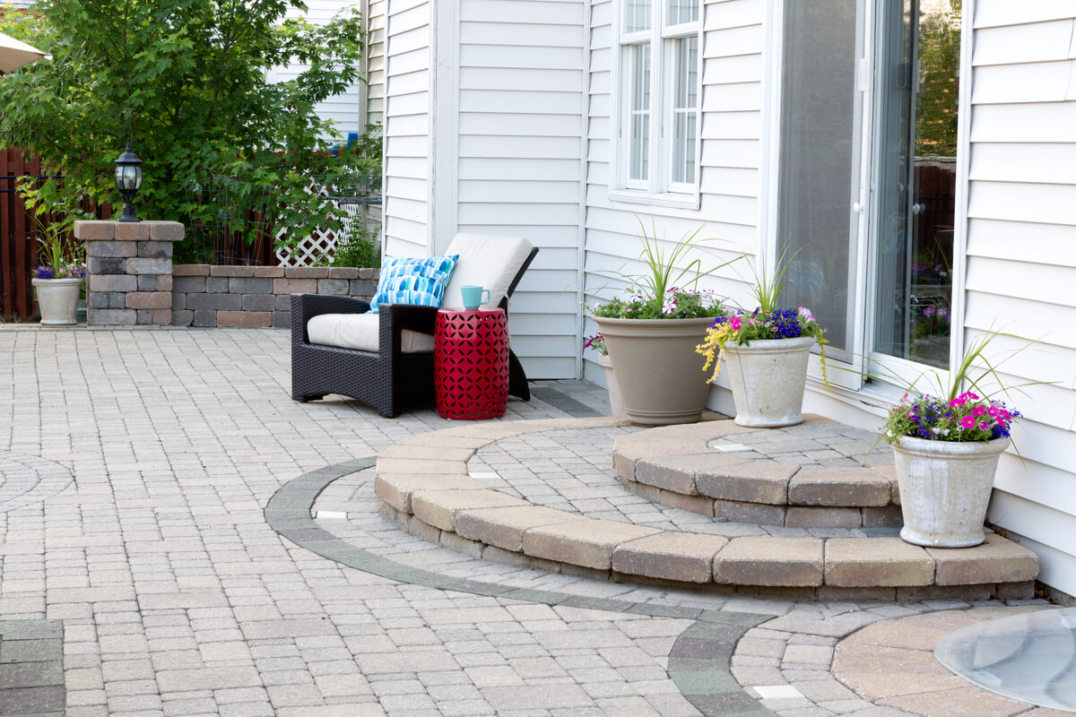 A brick patio with a curved walkway