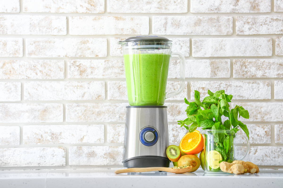 A blender filled with a green smoothie