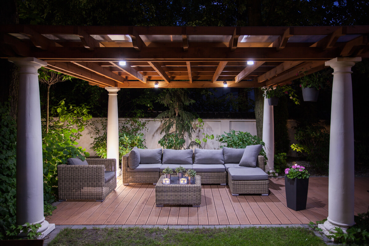 A patio with a pergola at night